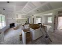 Open-concept living room features a fireplace, large windows, and rough-in kitchen cabinets at 125 Tee Dr, Selma, NC 27576