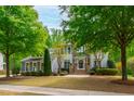 Inviting two-story home with stone accents, a manicured lawn, and lush landscaping, creating great curb appeal at 12833 Edsel Dr, Raleigh, NC 27613