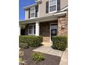 Welcoming home entrance features stone facade, inviting front door decor, manicured shrubs, and a cozy, covered entryway at 141 Steel Hopper Way, Garner, NC 27529