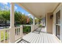 Inviting covered porch with white railings, ceiling fan, and ample space for relaxing at 1526 Town Home Dr, Apex, NC 27502