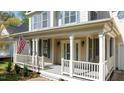 Charming front porch with decorative sconces flanking the front door and painted railings at 1526 Town Home Dr, Apex, NC 27502
