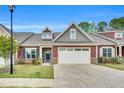 Charming exterior of home with two-car garage, stone accents and manicured lawn at 153 Telluride Trl, Garner, NC 27529