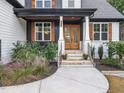 Inviting front entrance featuring a stone stairway, a wood door, and manicured landscaping at 188 E Antebellum Dr, Pittsboro, NC 27312