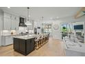 Spacious kitchen with black cabinets, granite countertops, and bar seating for five at 188 E Antebellum Dr, Pittsboro, NC 27312