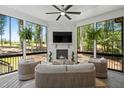 Cozy sunroom with a stone fireplace, mounted TV, and comfortable seating at 188 E Antebellum Dr, Pittsboro, NC 27312