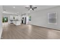 Open-concept living room features hardwood floors and a ceiling fan adjacent to modern kitchen at 201 Benton Dr, Oxford, NC 27565