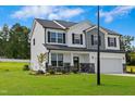 Charming two-story home with a two-car garage, stone accents, and professionally landscaped front yard at 21 Green Links Dr, Cameron, NC 28326