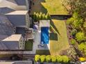 An aerial view of the backyard features a pool, patio, lush lawn and well-manicured landscaping at 212 Blue Granite Dr, Holly Springs, NC 27540