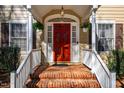 Close-up of the inviting red front door with white trim and decorative hanging flower baskets at 213 Huntington Dr, Chapel Hill, NC 27514