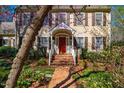 Welcoming front entrance featuring a brick walkway, a bright red door, and decorative floral accents at 213 Huntington Dr, Chapel Hill, NC 27514