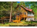 Inviting two-story home with wooden decks and steps, surrounded by mature trees and a green lawn at 2281 Lamont Norwood, Pittsboro, NC 27312