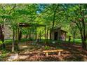 Serene backyard setting with a charming gazebo and a rustic wooden shed amidst lush greenery at 2281 Lamont Norwood, Pittsboro, NC 27312