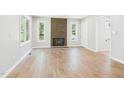 Bright living room featuring a brick fireplace, fresh white walls, and beautiful hardwood flooring at 2419 George Anderson Dr, Hillsborough, NC 27278