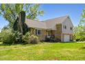 Two-story home featuring brick and siding exterior, front yard, and chimney covered with vines at 2510 Poplar Creek Rd, Henderson, NC 27537