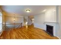 Bright living room featuring a fireplace, hardwood floors, and an open staircase at 2750 Laurelcherry St, Raleigh, NC 27612