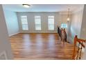 Open-concept living room with hardwood floors, large windows, and a staircase at 2750 Laurelcherry St, Raleigh, NC 27612
