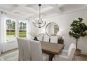 An elegant dining room with a wooden table, decorative lighting, and a window view of the outdoors at 315 Adams Pointe Ct, Angier, NC 27501