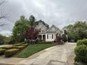 Beautiful home with stone and siding, a front porch, red maple trees, and long driveway at 3300 Magical Pl, Raleigh, NC 27614