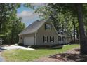 Exterior view of home with a two-car garage and lush green yard at 3813 W West Lake Rd, Apex, NC 27539