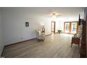 Spacious living room featuring wood-look floors, ceiling fan, and a door to the backyard at 3813 W West Lake Rd, Apex, NC 27539