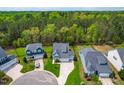 Expansive aerial view showcasing the home's setting within a lush, green, tree-lined neighborhood at 408 Price Lake Way, Fuquay Varina, NC 27526