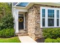 Inviting front entrance with stone accents, a vibrant wreath, and well-maintained landscaping at 408 Price Lake Way, Fuquay Varina, NC 27526