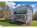 Charming home with covered porch and rocking chairs, brick and vinyl siding at 4424 Bonnie Loch Dr, Burlington, NC 27215