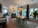 Open-concept dining area featuring stylish decor, wood floors and a cozy fireplace at 510 Braden Dr, Durham, NC 27713