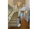 Spacious foyer featuring a staircase with wood railings, carpeted steps, and lots of light at 510 Braden Dr, Durham, NC 27713