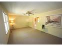 Bright living room with large window, neutral carpet, ceiling fan, and open access to other areas at 5202 Lorbacher Rd, Apex, NC 27539