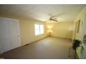 Spacious living room featuring a ceiling fan, large window, and ample natural light at 5202 Lorbacher Rd, Apex, NC 27539