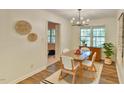 Bright dining room with wood floors, modern light fixture, and decorative wall art at 775 Old Graham Rd, Pittsboro, NC 27312