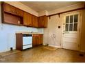 Traditional kitchen with wood cabinets, white appliances, and a back door at 810 Nancy St, Durham, NC 27701