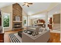 Inviting living room features stone fireplace, hardwood floors, and is adjacent to the open kitchen at 83 Calabria Ct, Clayton, NC 27527