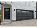 Close-up of the home's black garage door and entry featuring wood support beam at 834 Day Ave, Burlington, NC 27217