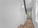 Bright hallway featuring wood floors, white walls, natural light and a staircase with a black handrail at 836 Day Ave, Burlington, NC 27217