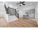 Open-concept living area showcasing hardwood floors, a staircase, and modern kitchen with gray cabinets at 836 Day Ave, Burlington, NC 27217