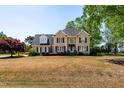 Charming two-story brick home with classic design, manicured lawn, and beautiful landscaping at 8409 Muirfield Dr, Fuquay Varina, NC 27526