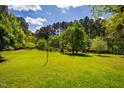 Expansive green backyard offers plenty of space for recreation and outdoor activities on a sunny day at 910 Old Orchard Rd, Chapel Hill, NC 27517