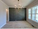 Dining room featuring a modern chandelier, a decorative accent wall, and large windows at 921 Lily Claire Ln, Fuquay Varina, NC 27526