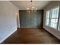 Bright dining room boasts wood floors, decorative chandelier, and a stylish accent wall at 921 Lily Claire Ln, Fuquay Varina, NC 27526
