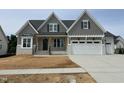 Beautiful craftsman home featuring a gray shingle exterior, white painted brick and a two-car garage at 921 Lily Claire Ln, Fuquay Varina, NC 27526