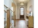 Welcoming foyer featuring hardwood floors, elegant lighting, and a stylish wooden door at 921 Lily Claire Ln, Fuquay Varina, NC 27526