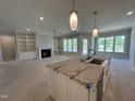 Spacious living room open to kitchen, featuring fireplace with built-ins, and large windows at 921 Lily Claire Ln, Fuquay Varina, NC 27526