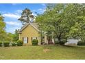 Inviting home exterior featuring manicured landscaping, a fountain, and a quaint walkway leading to the front door at 9332 Leslieshire Dr, Raleigh, NC 27615