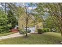 A lovely home features a two-car garage with a driveway, surrounded by lush greenery and manicured landscaping at 9332 Leslieshire Dr, Raleigh, NC 27615