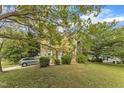 This home boasts a lush front yard with mature trees, providing ample shade and curb appeal at 9332 Leslieshire Dr, Raleigh, NC 27615