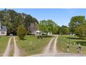 Picturesque property with a long driveway leading to a charming home with a welcoming front porch and well-kept lawn at 10 Gray Bass Ct, Zebulon, NC 27597