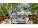 Lake house with large deck, showcasing an outdoor living space and natural surroundings at 104 Chuckwagon Dr, Louisburg, NC 27549
