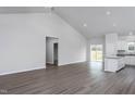 Open-concept living space with wood-look floors, vaulted ceiling, and seamless transition to the kitchen area at 11470 International Dr, Middlesex, NC 27557